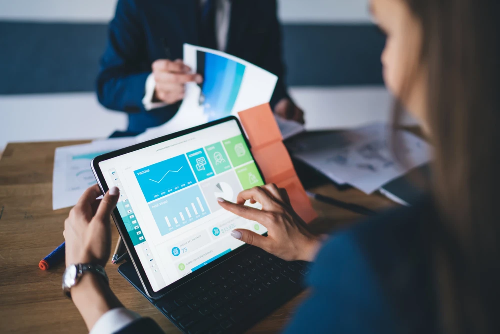 Réunion d'affaires dans un bureau moderne avec deux professionnels analysant des données financières