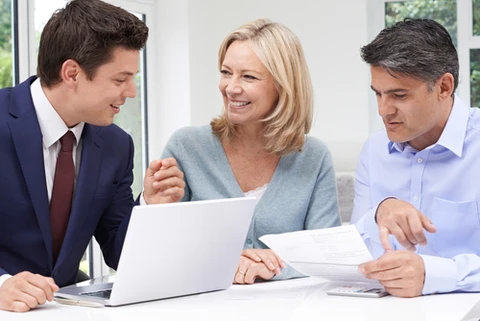 Deux professionnels en tenue d'affaires analysent des données financières dans un bureau moderne